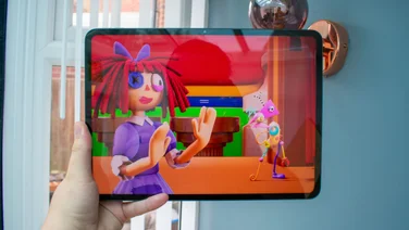 Oppo Pad 5 in hand, front view, displaying a cartoon
