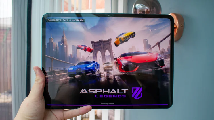 Oppo Pad 5 in hand, front view, displaying a mobile game