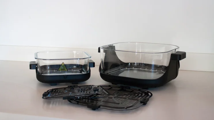 The Salter Crisp & Go air fryer's 4l and 1.5l dishes, alongside crisping plates, on a kitchen counter