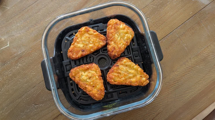 A bird's eye view of cooked hash browns in the dish of the Salter Crisp & Go air fryer