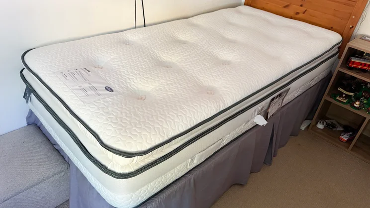 The Silentnight UltraGel Miracoil Pillowtop mattress on a bed frame in a bedroom