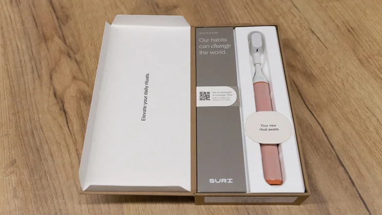 The Suri Core 1.0 electric toothbrush in its box, on an office table