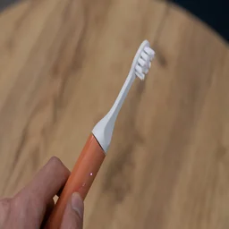 The Suri Core 1.0 electric toothbrush, switched on, held in the hand