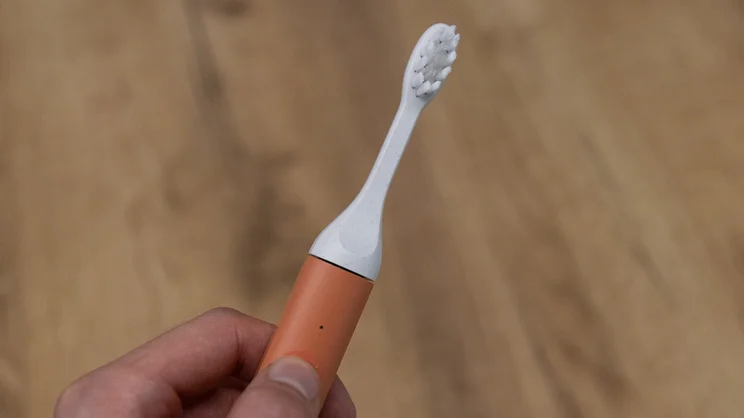 The Suri Core 1.0 electric toothbrush held in a hand