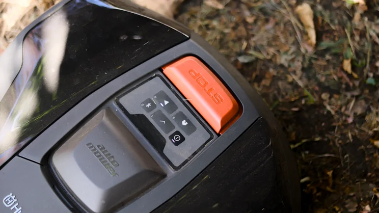 The Husqvarna Automower 308V pictured with a close up of the control panel and stop button