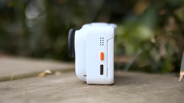 The Insta360 Go Ultra pictured in the dock from the left side
