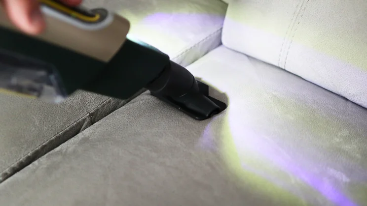 The Shark PowerDetect Transformer in handheld mode cleaning a sofa