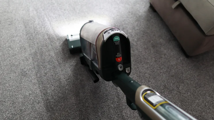 The Shark PowerDetect Transformer vacuuming carpet with headlight on