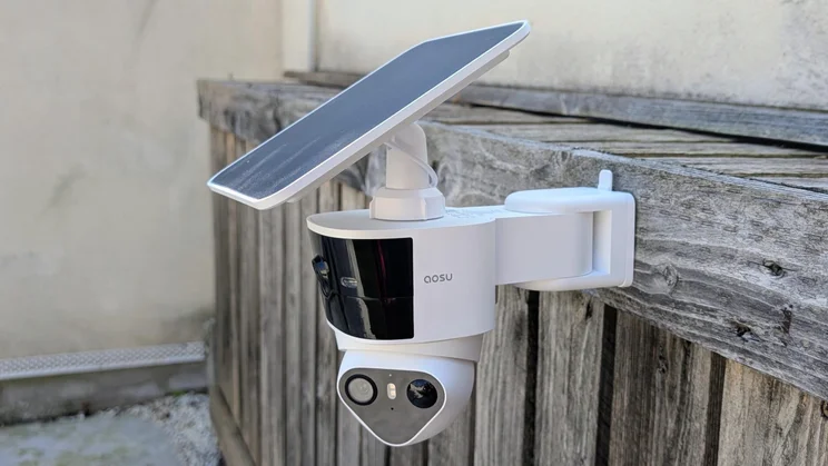 The Aosu Solarcam T2 Pro security camera attached to a wooden surface with its solar panel mounted on top