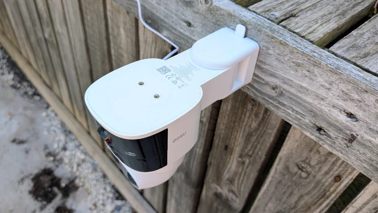 Top-down view of the Aosu Solarcam T2 Pro security camera attached to a wooden surface