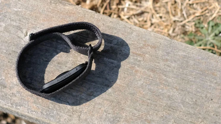 The Garmin Cirqa tracker lying on its side on a wooden bench
