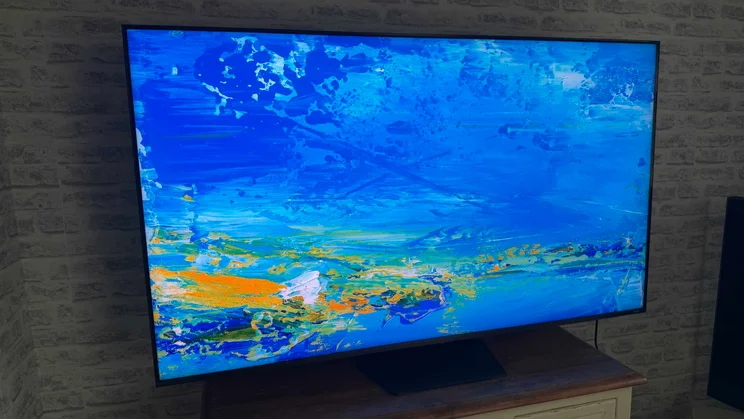 Left view of the Hisense UR9S RGB Mini LED TV displaying digital artwork of a watercolour lake painting