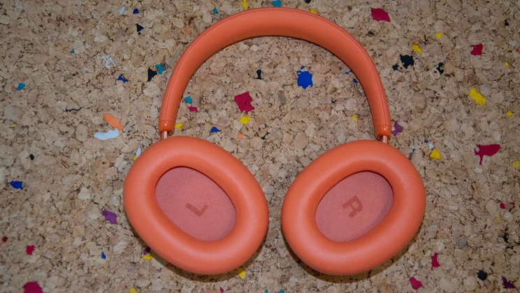 The JBL Live 780NC over-ear headphones lying on a cork table with their earcups facing upwards