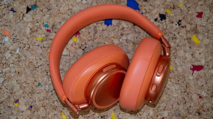 The JBL Live 780NC over-ear headphones folded up on a cork table