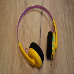 The Philips Ringo Duo on-ear headphones in yellow on a wooden table with their controls facing upwards