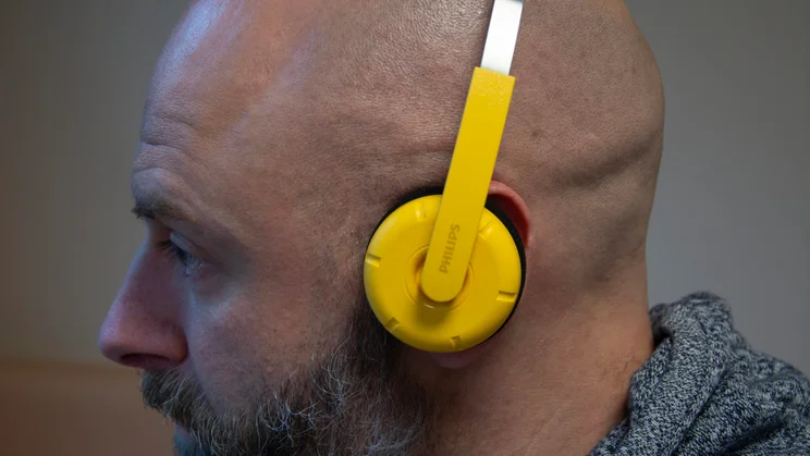Side view of the Philips Ringo Duo on-ear headphones in yellow being worn by our reviewer, Andy White