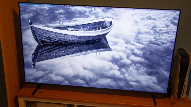The Samsung QN80H Mini LED TV displaying a black and white photo of a boat