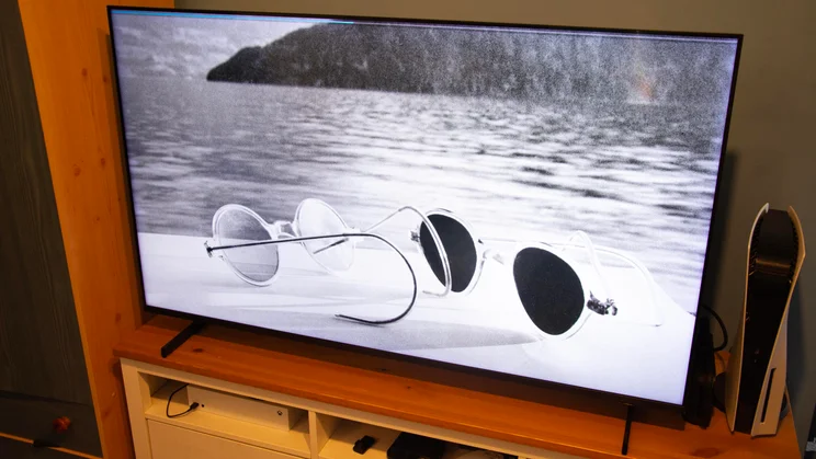 The Samsung QN80H Mini LED TV displaying a black and white picture of two pairs of sunglasses