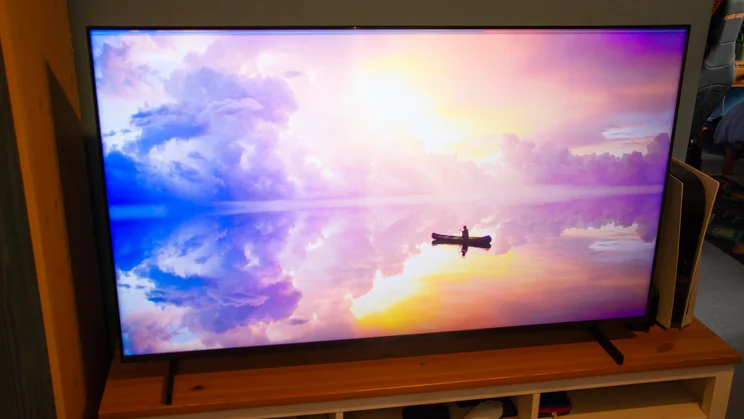 Front view of the Samsung QN80H Mini LED TV displaying a digital photograph of a boat at sea with the sun on the horizon
