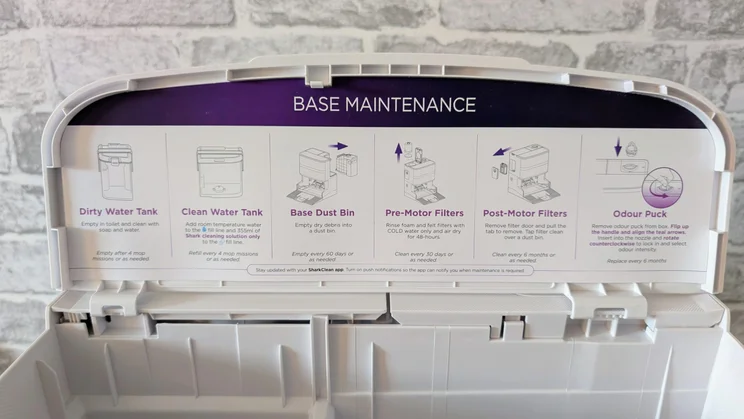 The base maintenance instructions on the docking station of the Shark PowerDetect UV Reveal 2-in-1 robot vacuum