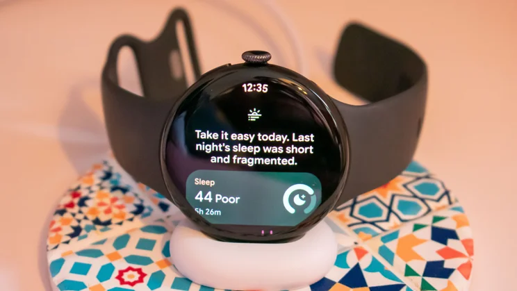 Google Pixel Watch 5 on the charging dock, displaying the morning brief sleep score