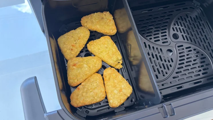 A bird's eye view of cooked hash browns in the open drawer of the Philips Airfryer 5000 Series Megabasket with Steam