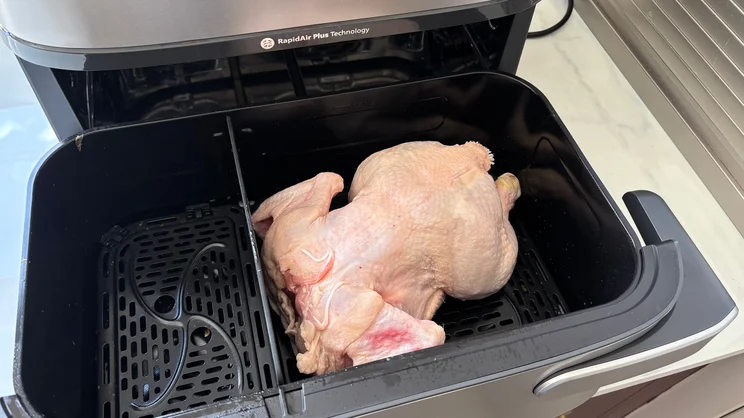 A raw chicken in the open drawer of the Philips Airfryer 5000 Series Megabasket with Steam