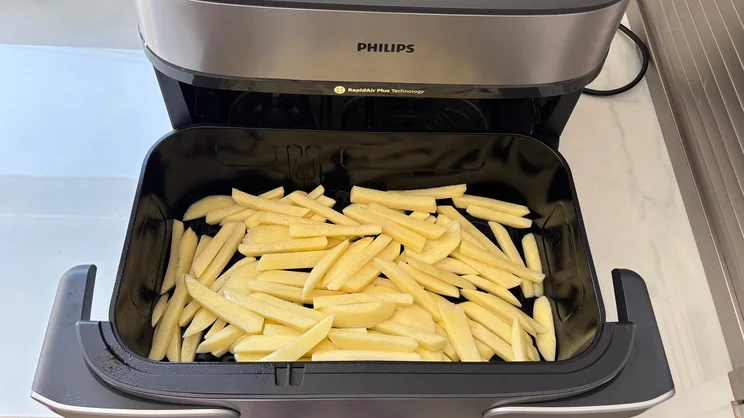 Raw chips in the open drawer of the Philips Airfryer 5000 Series Megabasket with Steam