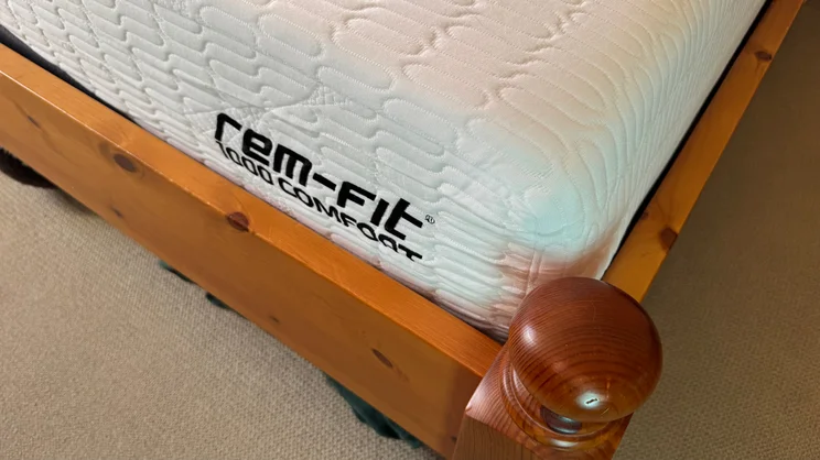 A closeup of the REM-Fit Pocket 1000 Hybrid mattress' corner and REM-Fit logo