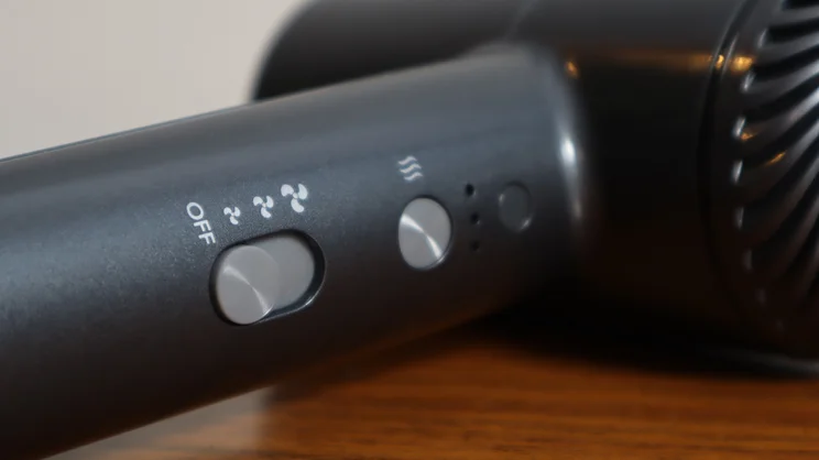 A closeup of the Revlon One Step Power Move hair dryer's controls