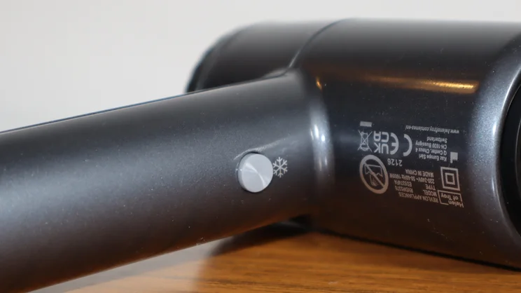 A closeup of the Revlon One Step Power Move hair dryer's cool shot button