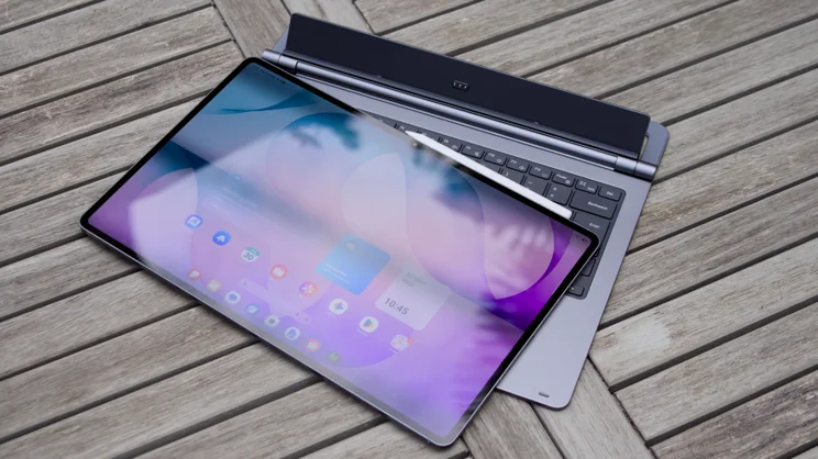 Samsung Galaxy Tab S12 Ultra lying flat on its keyboard cover on a slatted wooden table, with the hinge and connector panel behind it