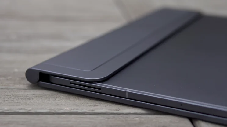 Close-up of the folded Samsung Galaxy Tab S12 Ultra edge, showing a speaker slot, the hinge cylinder and the cover's rounded corner