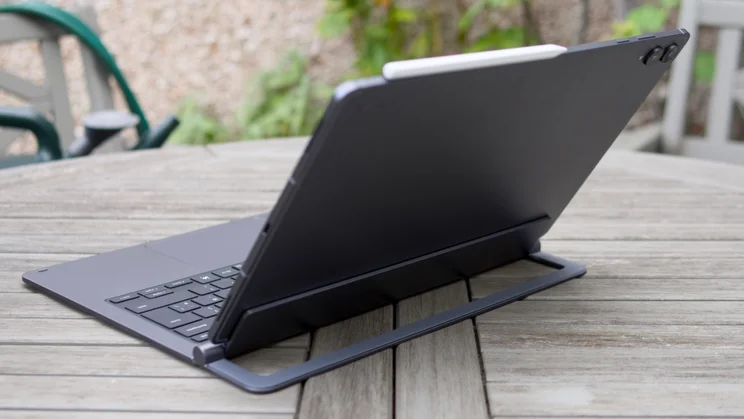 Rear three-quarter view of the Samsung Galaxy Tab S12 Ultra on its kickstand, with the keyboard, trackpad and top-edge volume buttons visible