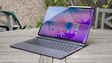 Samsung Galaxy Tab S12 Ultra propped up in its keyboard cover like a laptop on a weathered wooden garden table