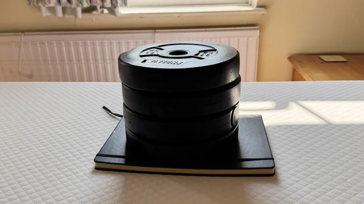 A stack of weights and a notebook being used to test sinkage on the Simba Simbatex Cool mattress