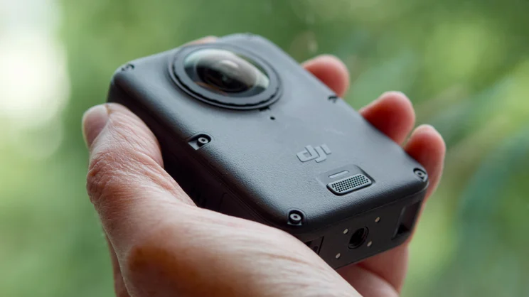 The DJI Osmo 360 II pictured being held in hand, from the front