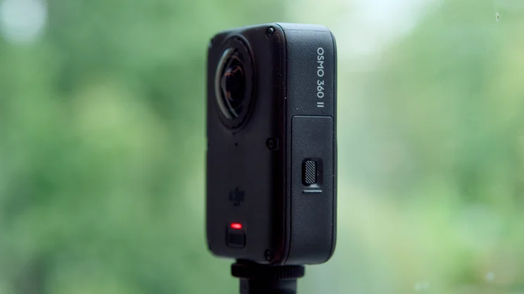 The DJI Osmo 360 II pictured on a selfie stick from the left side