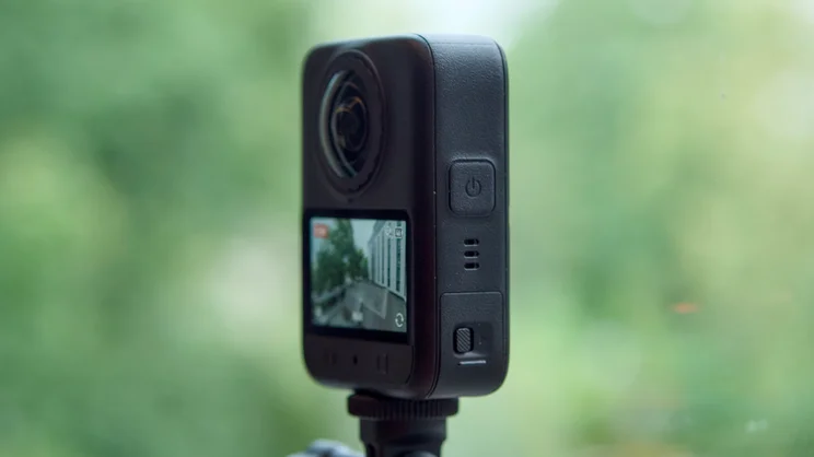 The DJI Osmo 360 II pictured on a selfie stick from the right side