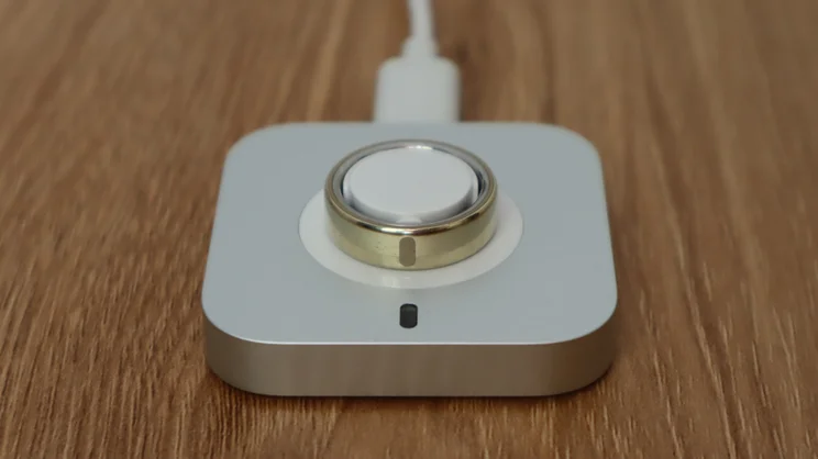 The Oura ring 5 chargiing on its charger
