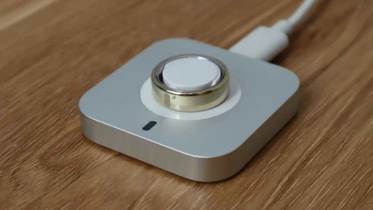 The Oura ring on its charger, pictured from the front right quarter