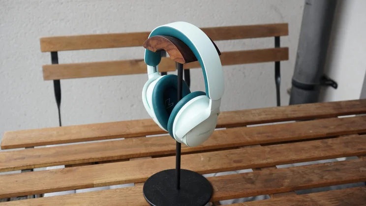 The Bose QuietComfort Headphones 2nd Gen on a headphones stand on a wooden slatted table