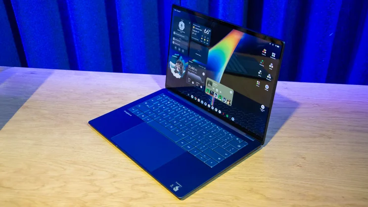 The HP Googlebook 14 clamshell laptop with its lid open on a wooden desk