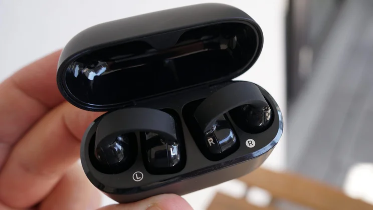 Close-up of the charging case of the Sennheiser Accentum Clip clip-on earbuds open with the buds inside