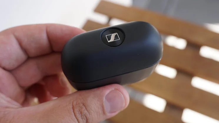 Top-down view of the charging case of the Sennheiser Accentum Clip clip-on earbuds open with the lid closed