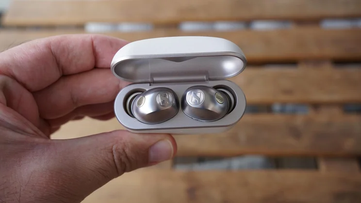Top-down view of the Sennheiser Momentum True Wireless 5 in their charging case being held with their lid open