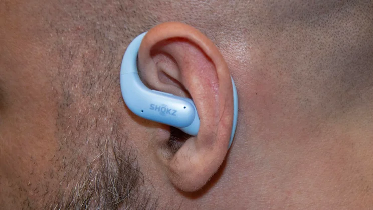 The left Shokz OpenFit Air 2 earbud being worn by a reviewer