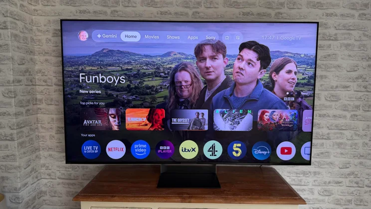 The Sony Bravia 9 II True RGB TV on a wooden table displaying the Google TV homepage
