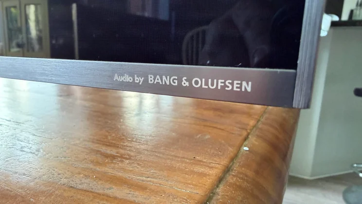 The Audio by Bang &amp; Olufsen logo on the bottom-right corner of the TCL C8L SQD Mini LED TV's panel