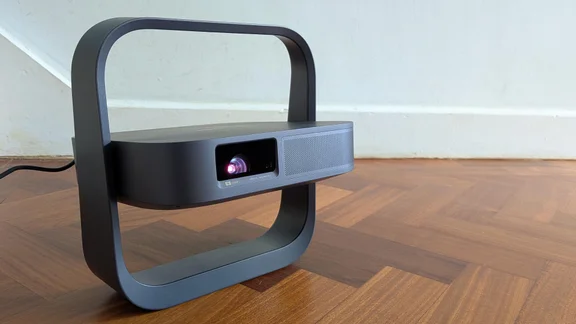 The XGIMI Elfin Flip Laser projector on a wooden floor facing to the right